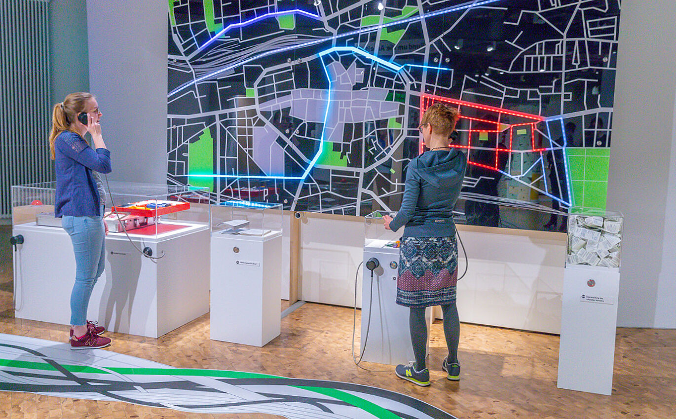 Scenographic infographics as part of the exhibition design is used interactively by two women