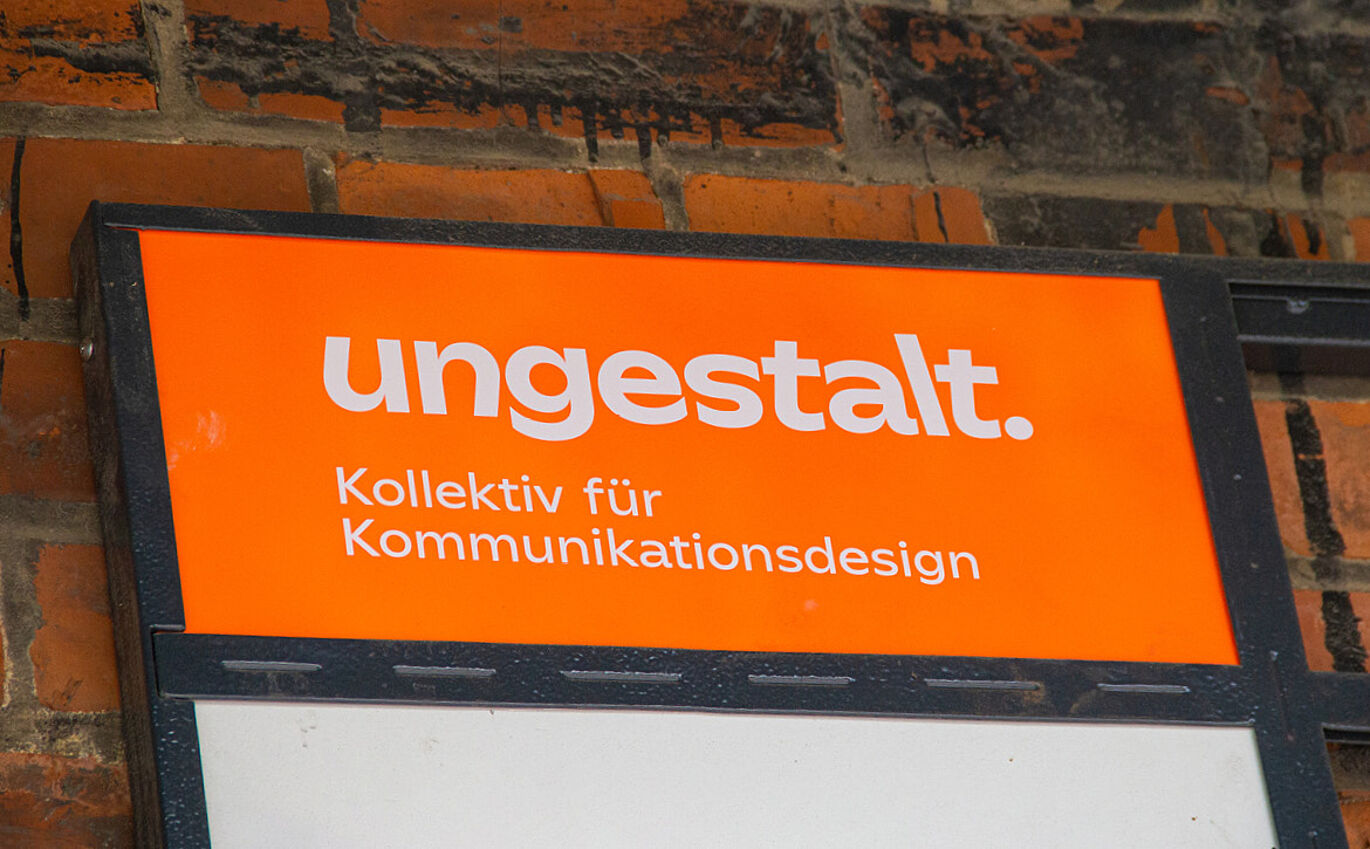 "ungestalt. Kollektiv für Kommunikationsdesign" branding on orange sign