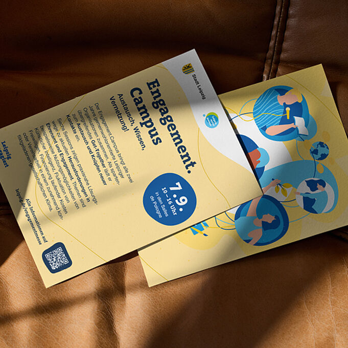 Die Vorder- und Rückseite eines Flyers liegt im Sonnenschein auf einem Sofa