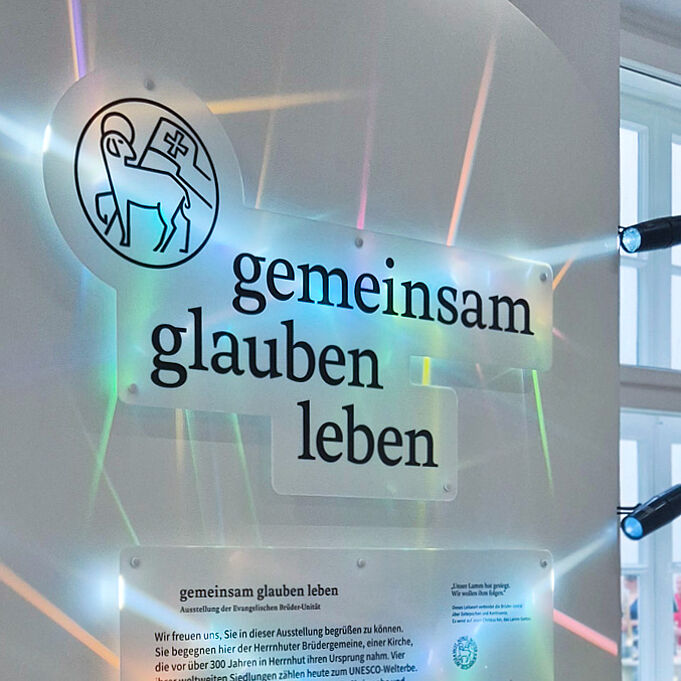 Nahaufnahme des angeleuchteten Key Visuals mit dem Ausstellungsnamen "gemeinsam glauben leben".