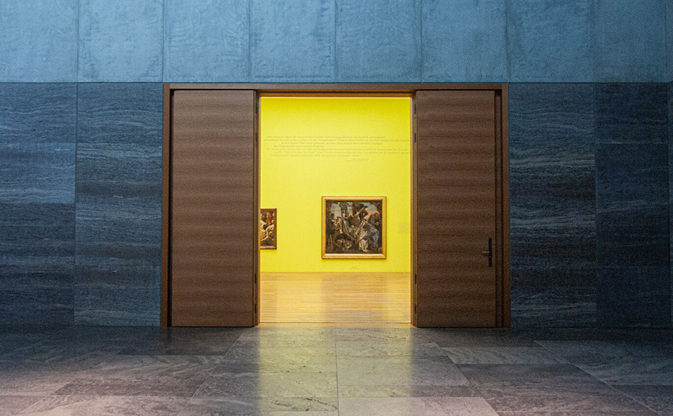 Führung Eingangsbereich des Ausstellungsraumes 'Klassische Morderne' welcher in einer gelben Wandgestaltung erstrahlt