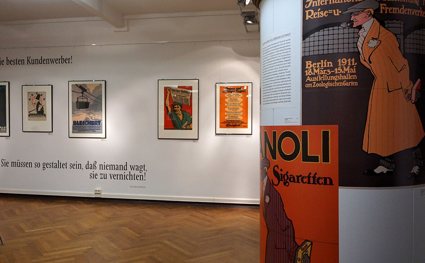 Ausstellungsraum mit Exponaten, Typografie Plakaten an einer Litfaßsäule und Typografie Design an der Ausstellungswand