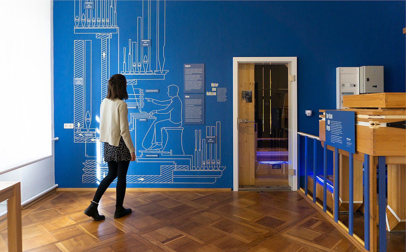 Ein Ton, viele Farben Ausstellungsraum mit kreativ gestalteter Infografikwand und den dazugehörigen Ausstellungstexten