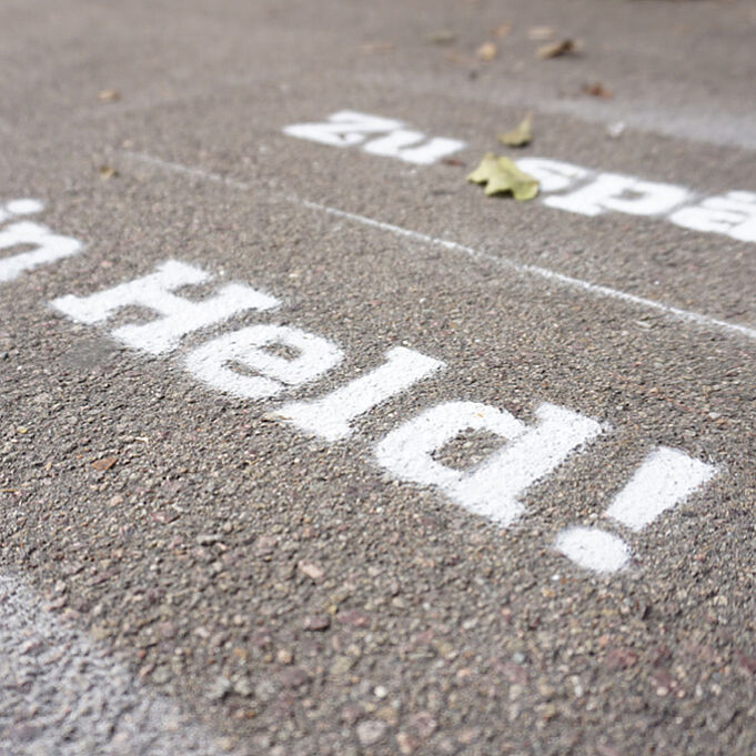 Schriftzug im Corporate Design von cityflitzer auf die Straße mit weißer Frabe gesprüht 