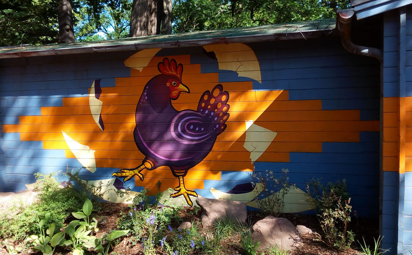Colorful facade painting of a chicken on the outer wall of the Leipzig petting zoo 