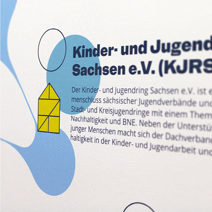 Nahaufnahme einer der Banner. Die Schrift sowie das Material des Banners sind in Detail zu sehen.