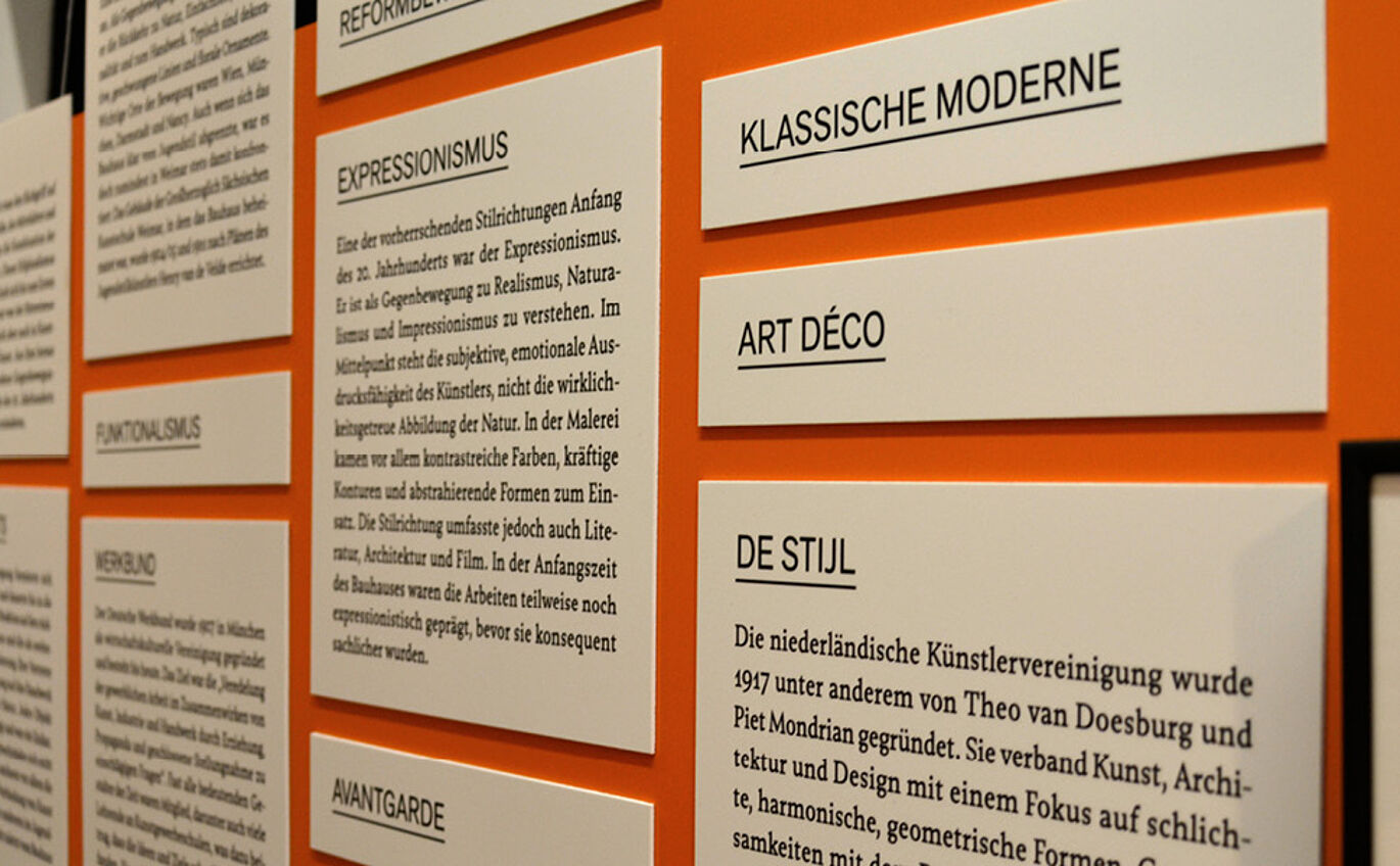 Black and white typography poster on orange exhibition wall 