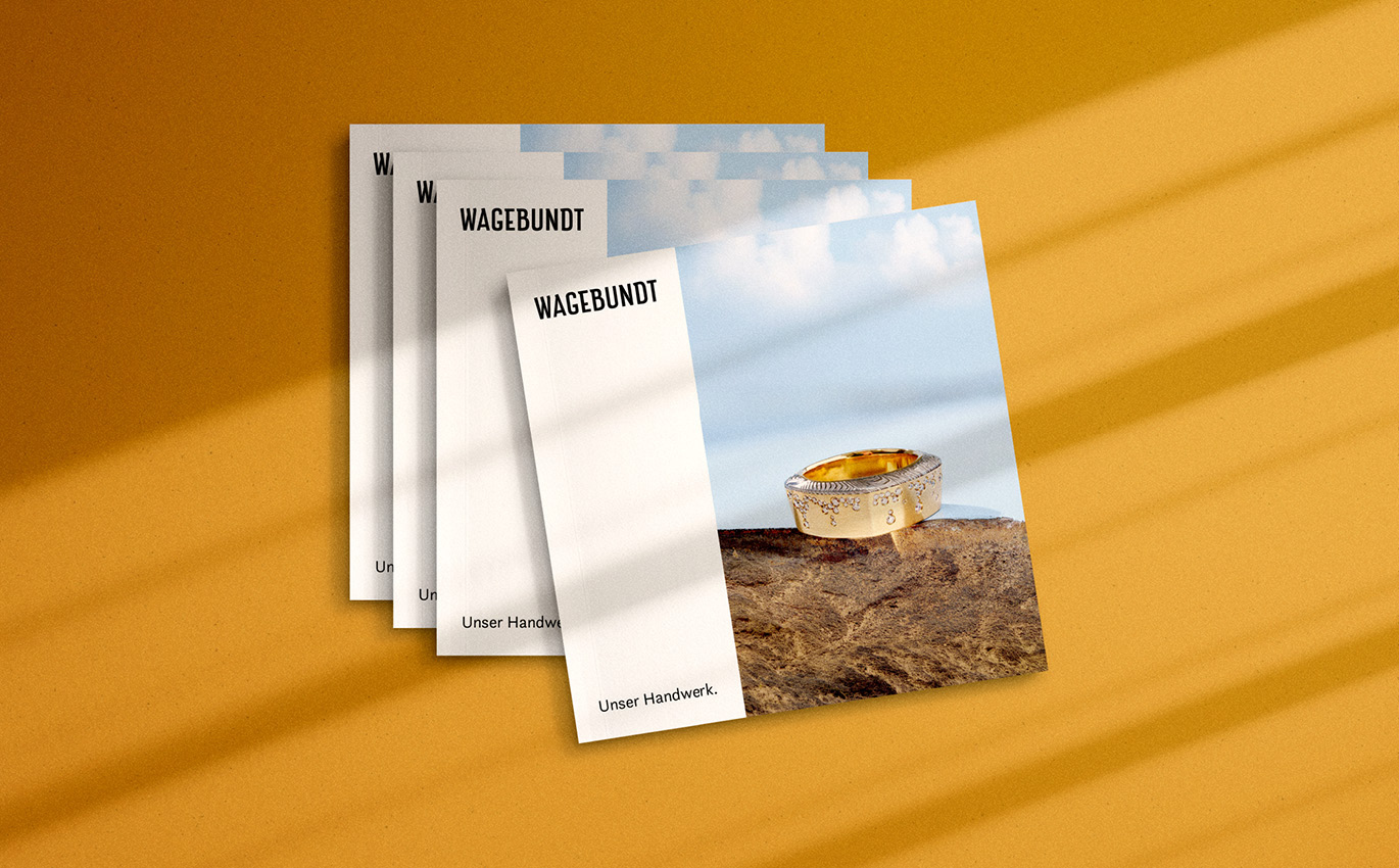 Grafik mehrerer Kataloge übereinander auf orangenem Hintergrund. Das Cover ist oben. Auf ihm steht "WAGEBUNDT" und kleiner darunter "Unser Handwerk.".