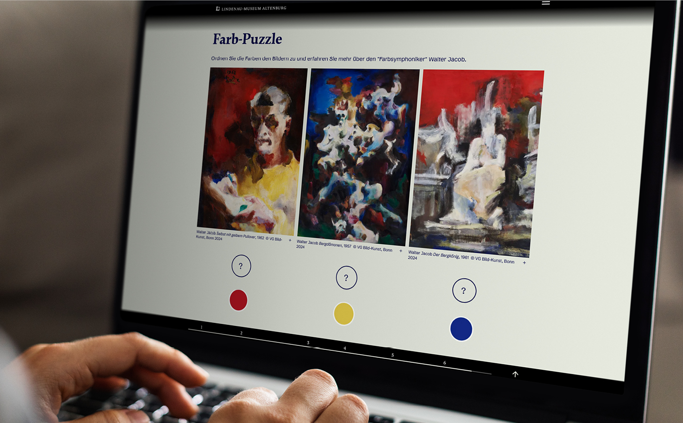 Das Bild zeigt einen aufgeklappten Laptop und Hände die auf der Tastatur zu tippen scheinen. Der Bildschirm zeigt ein "Farb-Puzzle". Drei bunte Bilder sind nebeneinander. Darunter sind Kreise der Farben rot, gelb und blau zu erkennen. Über den Farbkreisen befinden sich Fragezeichen.